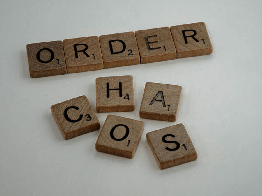 A vida vira um caos se não buscamos ser produtivos. Bloquinhos de madeira com letras formando as palavras: order (ordem) e chaos (caos).